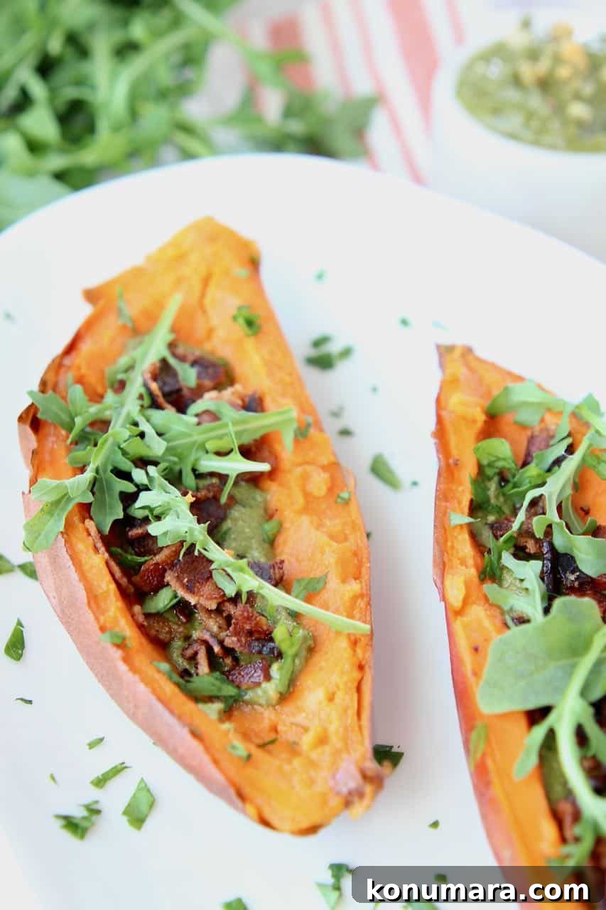 Loaded Sweet Potato Skins with Sage Pesto and Crispy Bacon 3 Loaded sweet potato skins with bacon and arugula on white plate