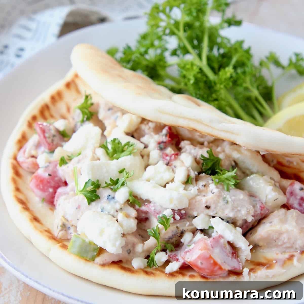 Greek Chicken Salad Pita with Tzatziki and Feta 2 chicken salad in pita bread on plate with parsley