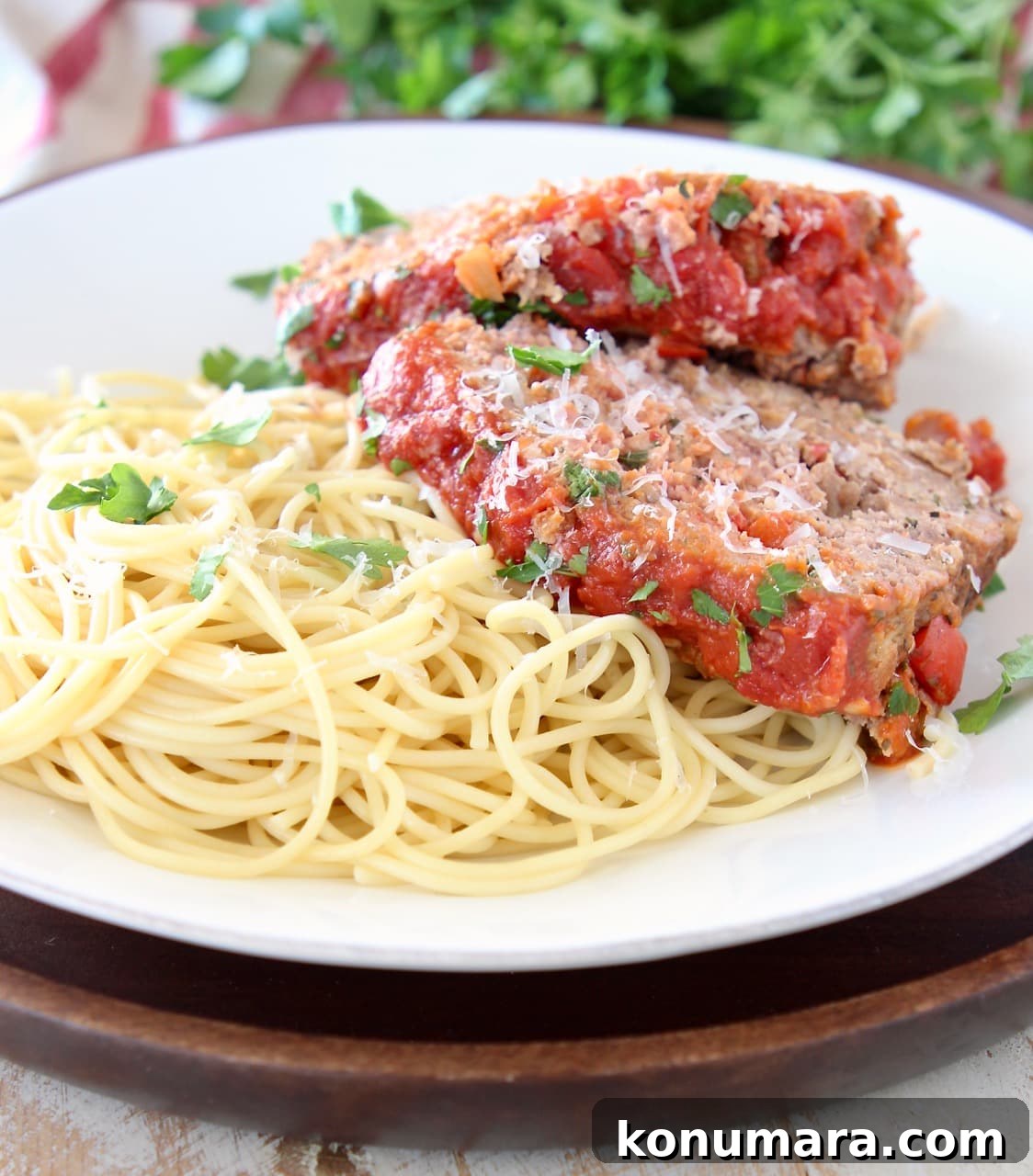 Classic Italian Meatloaf Recipe with Marinara Glaze 5 Two slices of Italian meatloaf on top of cooked spaghetti noodles on a white plate
