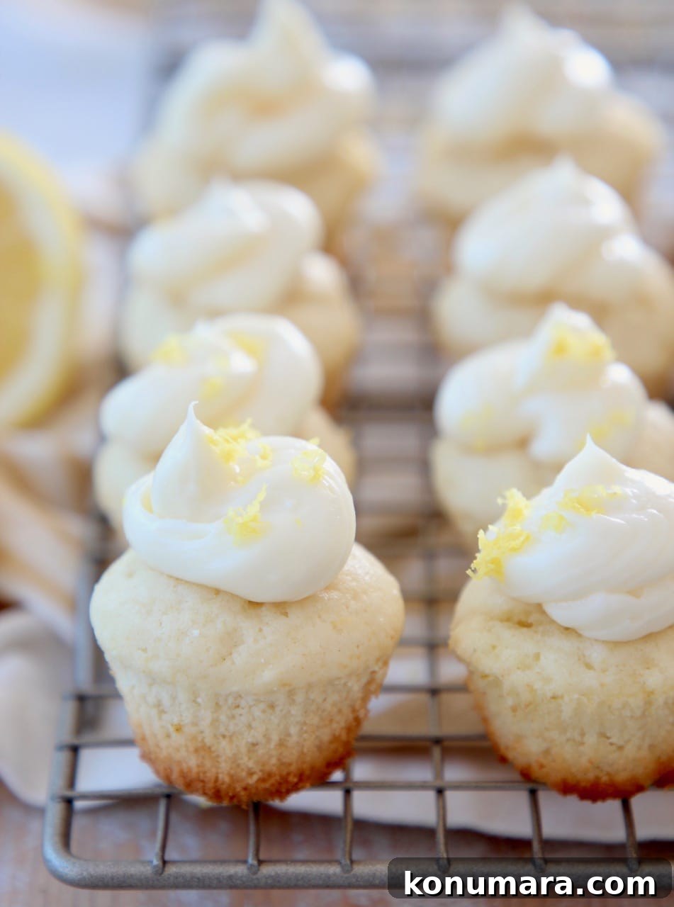 Miniature lemon cupcakes with lemon buttercream frosting on wire baking rack