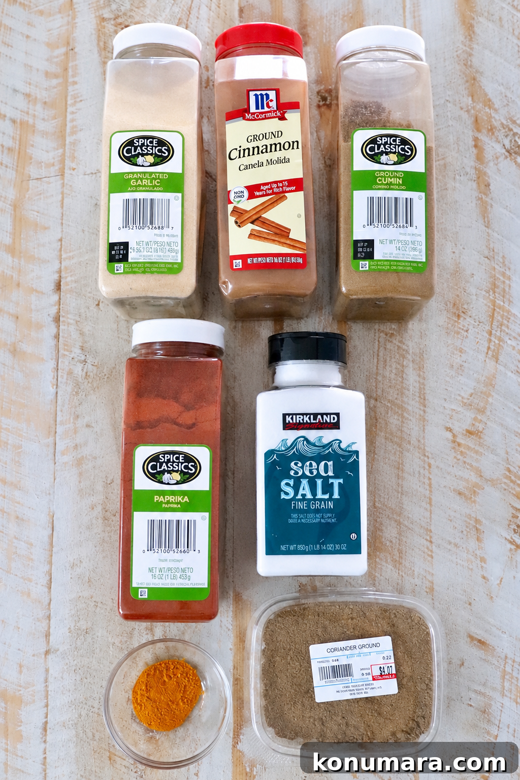 various spices in plastic containers on a white wood table