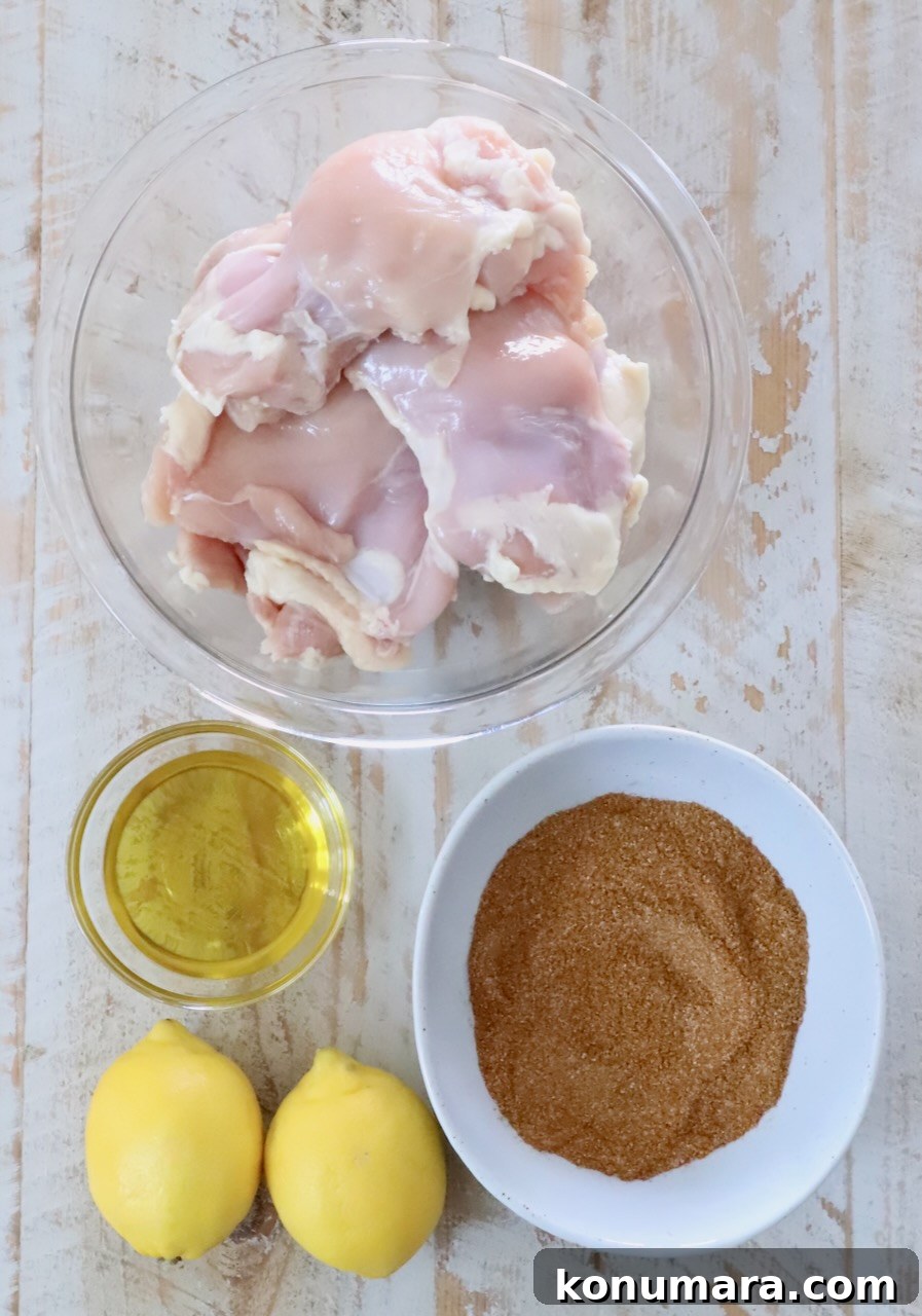 Chicken Shawarma Tacos with Garlic Yogurt Sauce 5 raw chicken thighs in a glass bowl, next to a small bowl of oil and seasoning mix, and two lemons