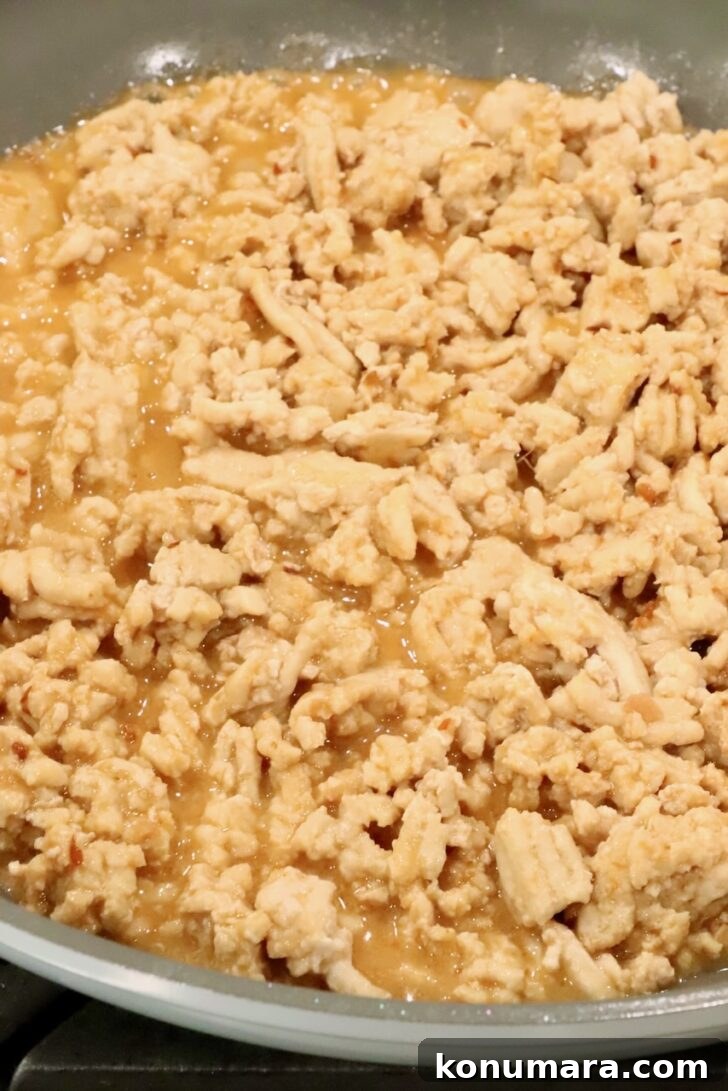 cooked ground chicken in a skillet covered with a miso ginger sauce